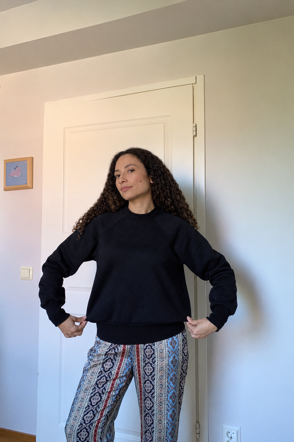 Modelo com camisola preta, cabelo e pele retocados naturalmente