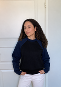 Modelo com camisola azul-marinho e preta, cabelo e pele retocados naturalmente