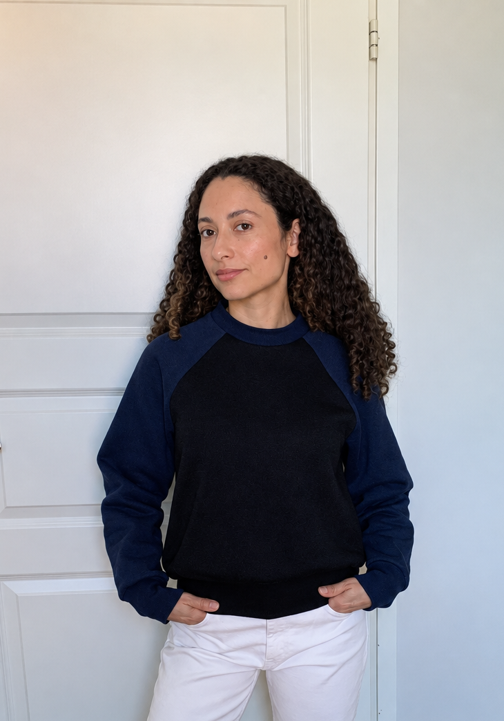 Modelo com camisola azul-marinho e preta, cabelo e pele retocados naturalmente